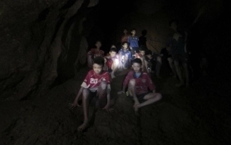 The boys and their soccer coach are shown as they were found Monday by rescuers, keeping dry in a partially flooded cave in Mae Sai, Chiang Rai, Thailand. After being trapped for 10 days, they were mostly in stable medical condition and have received high-protein liquid food, officials said Tuesday.