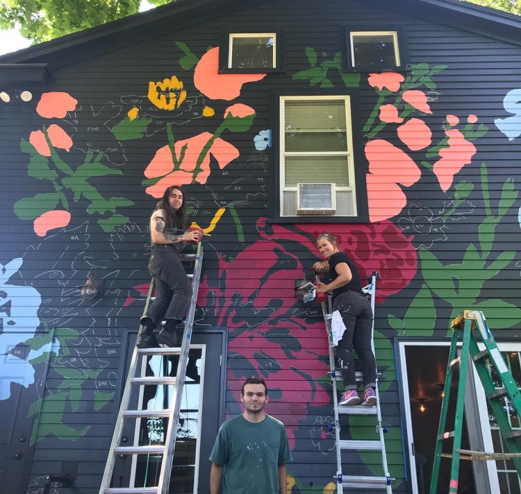 From left, Bee Marcellino, Baxter Koziol and Tessa O'Brien work on the new mural at Chaval.