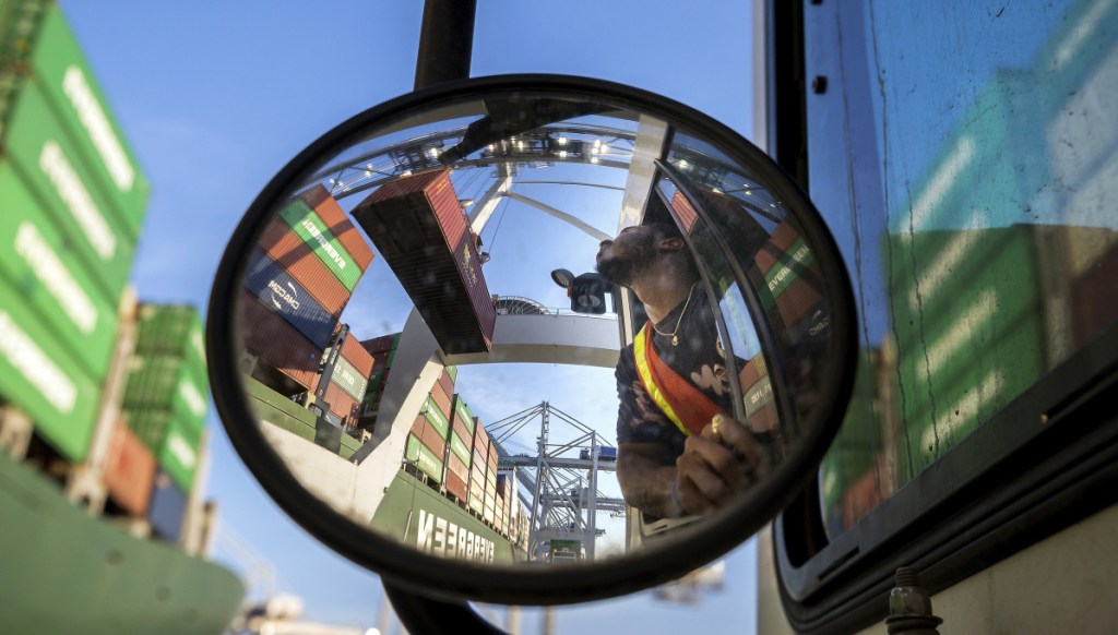 A mirror captures a jockey truck driver watching as a shipping container clears his trailer at the Port of Savannah in Savannah, Ga., in a file photo from last month. Starting Friday, the U.S. has imposed 25 percent duties on $34 billion in Chinese products; Beijing promptly responded with tariffs on an equal amount of American products.