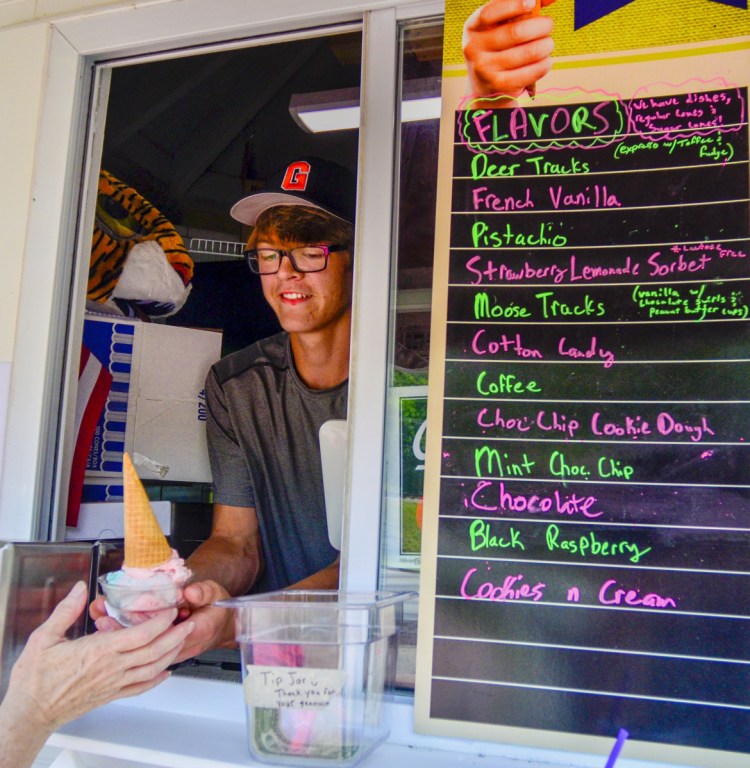 Alic Shorey serves a bowl of ice cream with a cone on top to a customer Tuesday at the Cat Shack. "It was a shock how much effort it actually is to get a successful business up and running," said Shorey, 18.