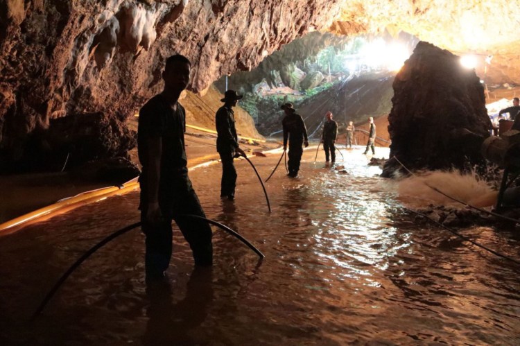 Rescue teams arrange a water pumping system at the entrance of a flooded cave, where 12 boys and their soccer coach had been trapped since June 23, in Mae Sai, Chiang Rai province, northern Thailand. 