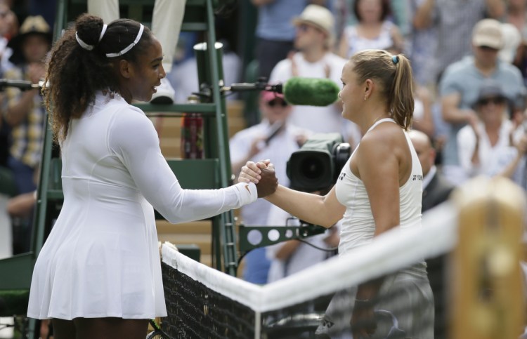 Serena Williams, left, shakes hands with Russia's Evgeniya Rodina after defeating her in straight sets Monday at the Wimbledon tennis championships in London. (AP Photo/Tim Ireland)