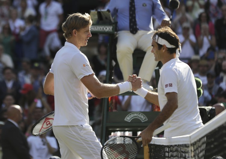 Kevin Anderson of South Africa, left, shakes hands with Switzerland's Roger Federer, after defeating him in their men's quarterfinals match at the Wimbledon Tennis Championships, in London, Wednesday July 11, 2018. (AP Photo/Ben Curtis)