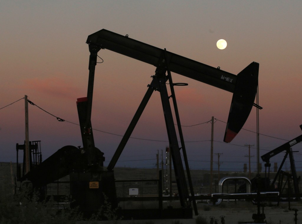 Oil derricks pump near the La Paloma Generating Station in McKittrick, Calif., in 2017. The U.S. could produce 11.8 million barrels of crude a day