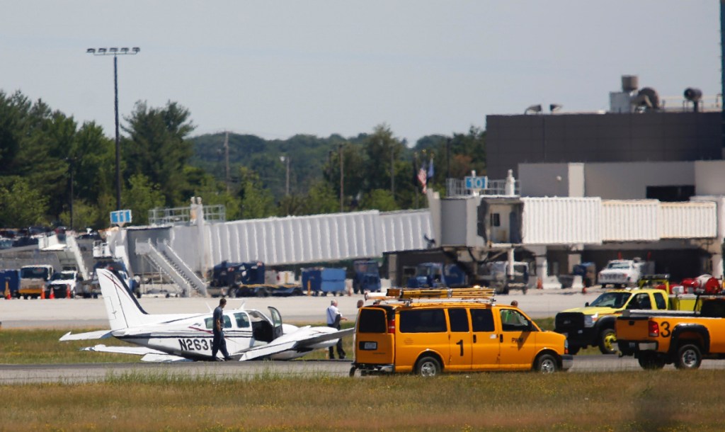 A twin-engine plane with two people aboard landed on its belly at Portland International Jetport on Thursday, causing all runways to close.