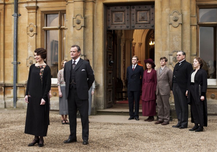 This undated publicity photo provided by PBS shows, from left, Elizabeth McGovern as Lady Grantham, Hugh Bonneville as Lord Grantham, Dan Stevens as Matthew Crawley, Penelope Wilton as Isobel Crawley, Allen Leech as Tom Branson, Jim Carter as Mr. Carson, and Phyllis Logan as Mrs. Hughes, from the TV series, "Downton Abbey." Focus Features said Friday, July 13, that it will this summer begin production on a "Downton" film that will reunite the Crawley family on the big screen. Series creator Julian Fellowes wrote the screenplay and will produce. (AP Photo/PBS, Carnival Film & Television Limited 2012 for MASTERPIECE, Nick Briggs)