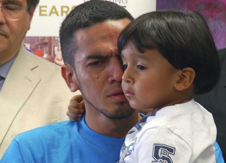 In this image taken from video, Javier Garrido Martinez holds his 4-year-old son Wednesday after they were reunited, during a news conference in New York. The Trump administration faces another deadline this month to reunify families separated at the border.