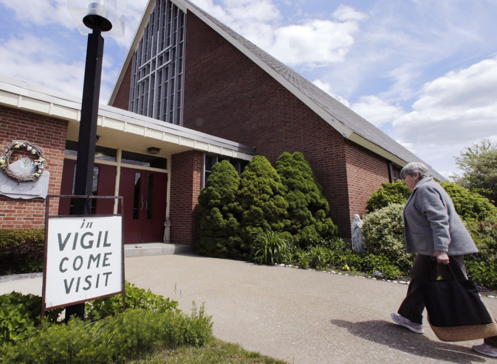 A former parishioner at the St. Frances Xavier Cabrini Church in Scituate, Mass., arrives to help keep vigil as the church was being closed by the Boston Diocese in 2015 to help deal with a priest shortage. As more churches close, the Vatican is hoping to ensure that the properties do not fall into inappropriate hands.