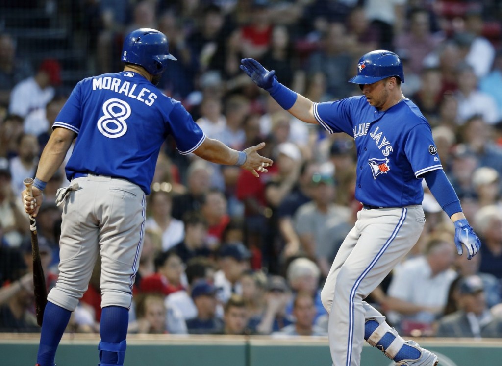 Justin Smoak, right, celebrates the first of his two home runs with Kendrys Morales during Toronto's 13-7 win over the Red Sox on Friday night.