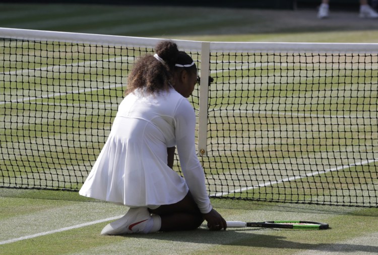 Serena Williams kneels at the net after missing a volley during the second set of her loss to Germany's Angelique Kerber at the Wimbledon Tennis Championships in London on Saturday.