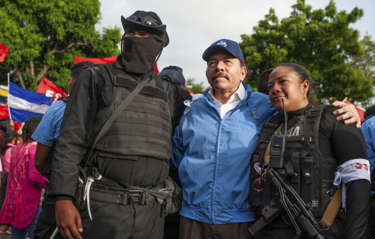 Nicaraguan police pose with President Daniel Ortega, in Masaya, Nicaragua, on Friday.