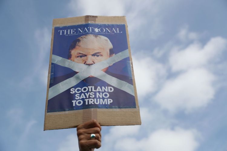 A demonstrator makes his feelings known as people gather to protest a visit by President Trump to Turnberry, Scotland, on Saturday.