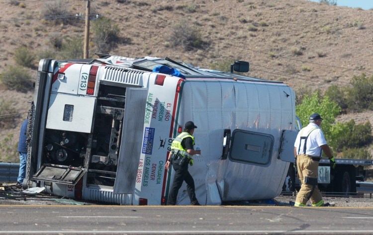 Emergency personnel work at the scene of a deadly crash involving a bus that occurred on Interstate 25 just north of Bernalillo, N.M., early Sunday. Three people died in the accident that also involved three other vehicles.