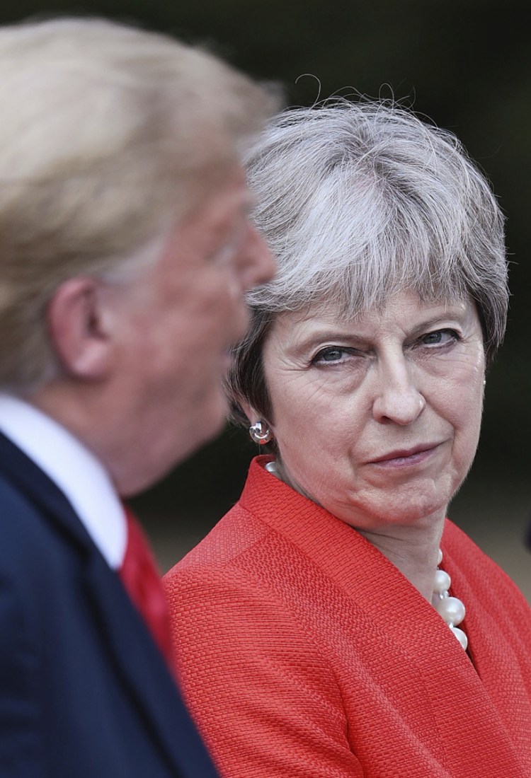 British Prime Minister Theresa May listens as President Trump speaks Friday during a news conference.