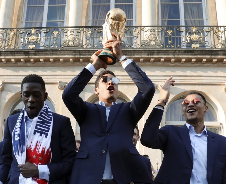 Alphonse Areola, a backup goalkeeper for France, shows off the World Cup trophy Monday during an official reception at the Elysee Presidential Palace in Paris.