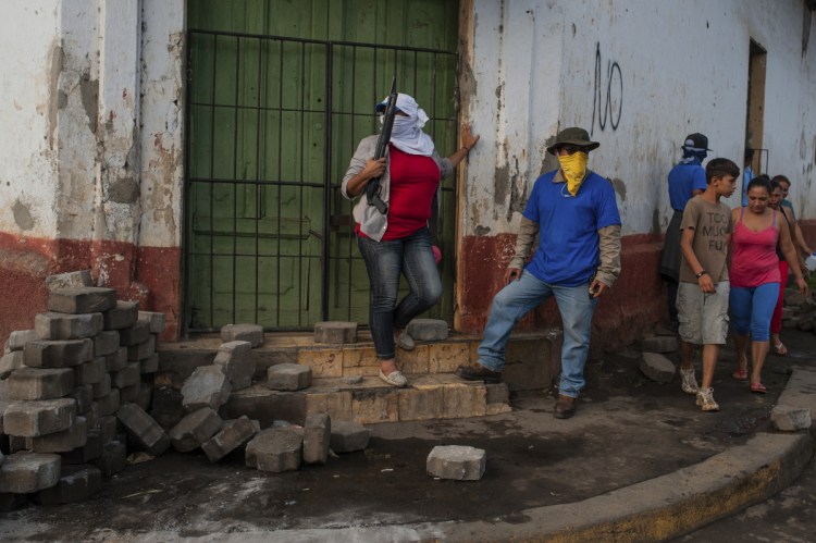 Sandinista militias stand guard at a torn down barricade after police and pro-government militias stormed the Monimbo neighborhood of Masaya, Nicaragua on Tuesday.