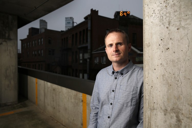 Michael Koryta poses for a photo in a parking garage in Portland's Monument Square. His latest book, "How it Happened," revolves around two missing bodies, the opioid epidemic in a coastal Maine town and a relentless FBI agent.