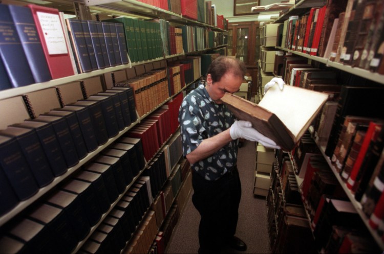 Greg Priore, an archivist at the Carnegie Library of Pittsburgh, examines books for preservation. Sammy Dallal/Pittsburgh Post-Gazette via AP