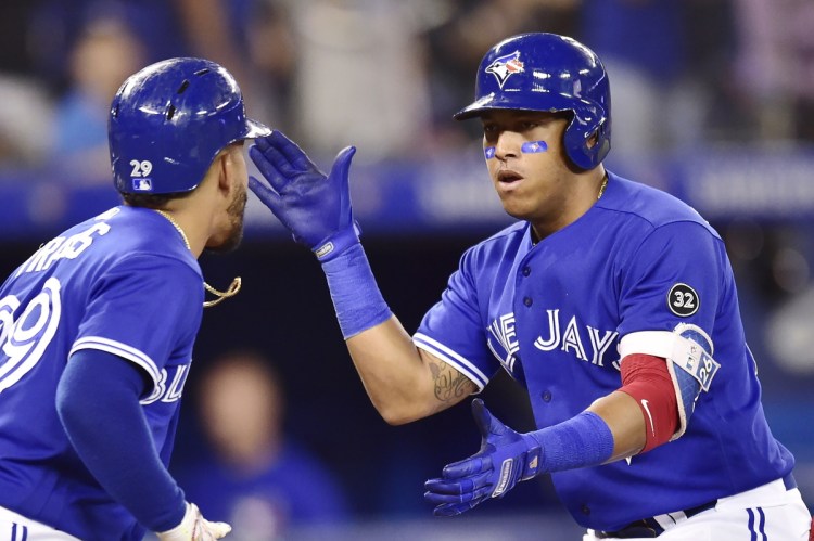 The Blue Jays' Yangervis Solarte, right, celebrates his eighth-inning, two-run homer with teammate Devon Travis in Sunday's home win over Baltimore.