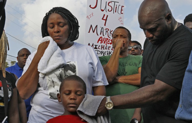 Michael McGlockton, right, the father of Markeis McGlockton, wipes the face of his grandson, Markeis McGlockton Jr., as protesters gathered Sunday in Clearwater Fla.