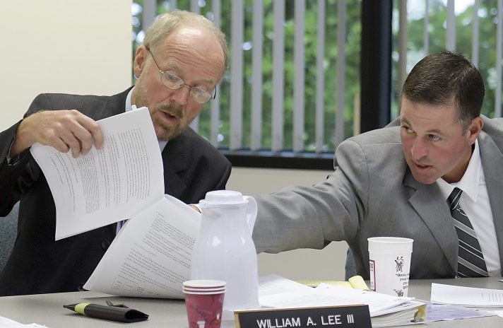 From left, Maine ethics commission members Richard Nass, William Lee III and Bradford A. Pattershall examine a document in July while hearing a Clean Elections complaint from House District 110 candidate Mark André in Augusta.