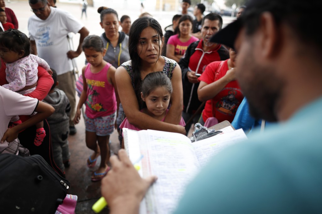 A woman from the Mexican state of Michoacan who did not give her name stands with her daughter as names are read off a list of people who will cross into the United States to begin the process of applying for asylum Thursday near the San Ysidro port of entry in Tijuana, Mexico. As the Trump administration faced a court-imposed deadline Thursday to reunite thousands of children and parents who were forcibly separated at the U.S.-Mexico border, asylum seekers continue to arrive to cities like Tijuana, hoping to plead their cases with U.S. authorities.