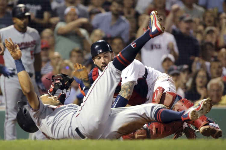 Minnesota's Eddie Rosario is tagged out by Red Sox catcher Blake Swihart while trying to score on a single by Brian Dozier in the sixth inning Thursday night in Boston.
