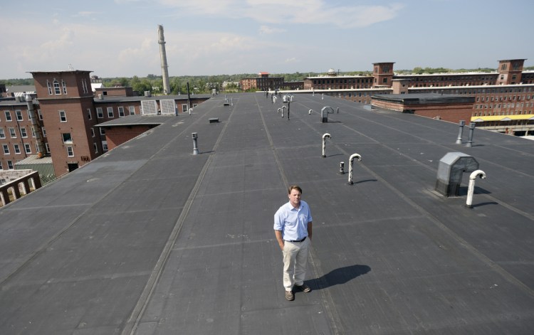 Scott Joslin, general manager of Pepperell Mill Campus in Biddeford, stands on the roof of one of his company's historic mill buildings. On Friday, his company announced plans to install nearly 1,200 rooftop solar panels to help power the campus. 