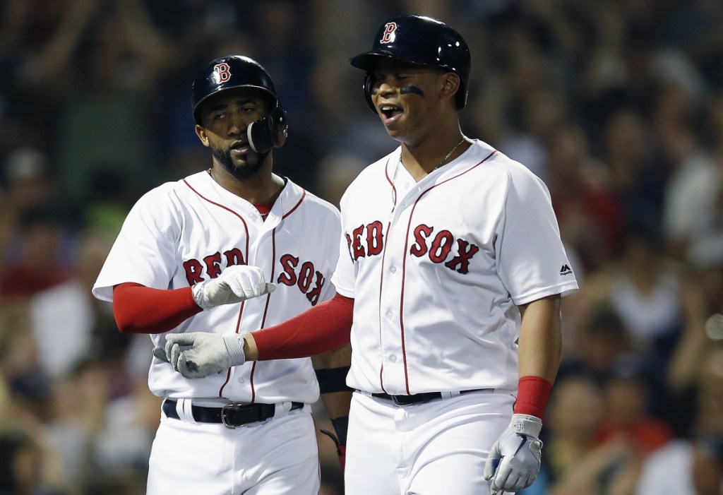 Rafael Devers, right, and Eduardo Nunez celebrate after scoring on a triple by Jackie Bradley Jr. in the fourth inning Saturday night against the Minnesota Twins. The Red Sox overcame a 4-1 deficit and pulled away late for a 10-4 victory. (Associated Press/Michael Dwyer)
