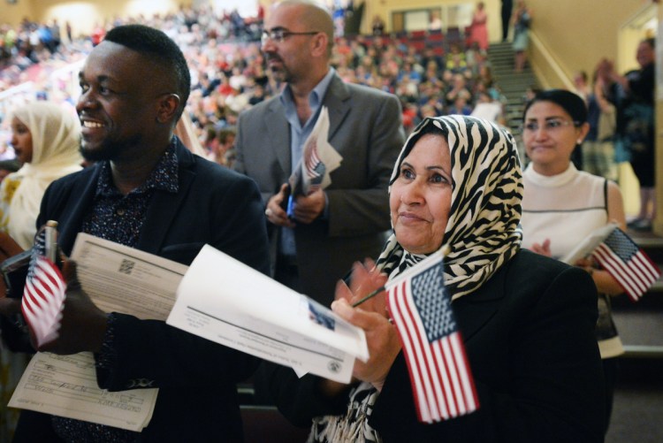 Sameerah Kadhin of Portland, who is originally from Iraq, holds a U.S. flag as she claps in June moments after she was sworn in as a U.S. citizen during a naturalization ceremony in Topsham. A reader who also is an immigrant notes that the flag means so much to her.