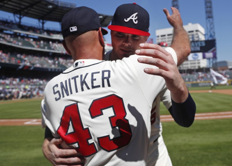 Atlanta pitcher Sean Newcomb, right, embraced Manager Brian Snitker after falling just short of a no-hitter Sunday. After the game he distanced himself from racist, homophobic tweets from his past.