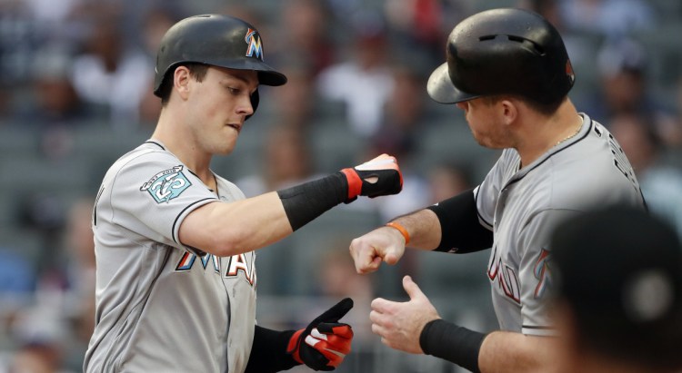 Brian Anderson of the Miami Marlins, left, celebrates with Justin Bour after hitting a two-run homer Monday night in the first inning at Atlanta. The Braves won, 5-3.