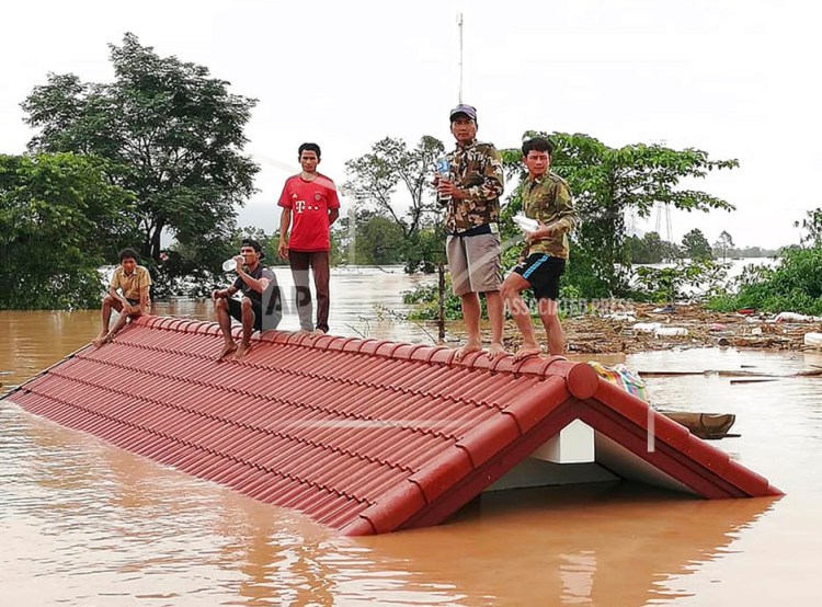 Villagers take refuge on a rooftop above floodwaters from a collapsed dam in the Attapeu district of southeastern Laos, Tuesday.