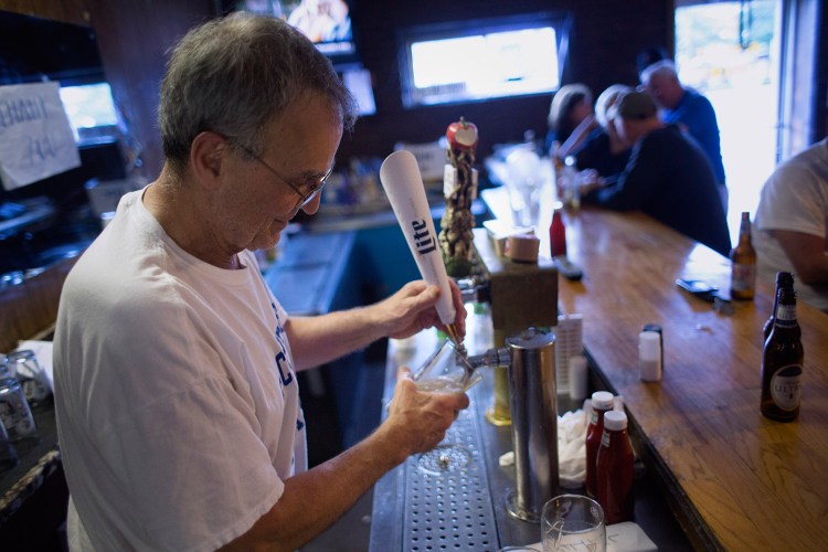 Richard Piacentini, owner of the Forest Gardens bar in Portland, pours a beer on Friday. He's retiring after running the bar for four decades. The new owners plan to keep it essentially the same.