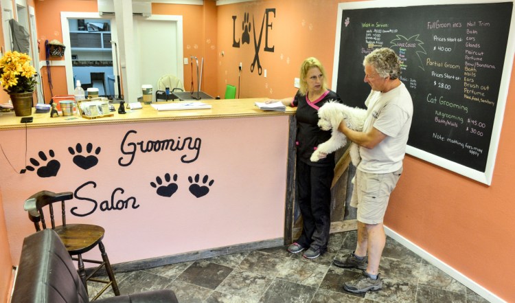 Melanie Hubble talks with Eric Guilt about how he wants her to groom his dog, Sam, on Friday at Wagging Tails Grooming Salon on Main Street in Winthrop.