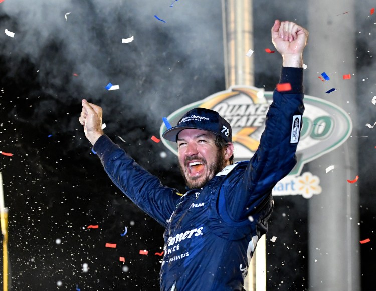 Martin Truex Jr. raises his arms in celebration following his victory in the NASCAR Cup Series race Saturday at Kentucky Speedway.