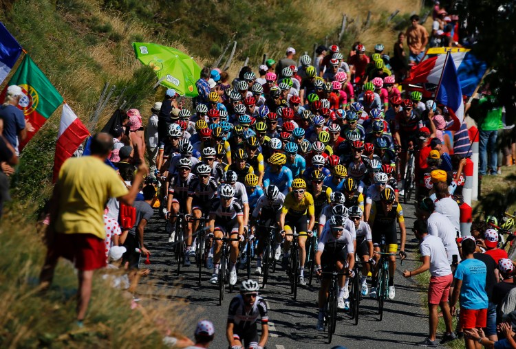 The pack with Britain's Geraint Thomas, wearing the overall leader's yellow jersey, front center, rides during the 14 stage of the Tour de France on Saturday in Saint-Paul Trois-Chateaux and Mende, France.