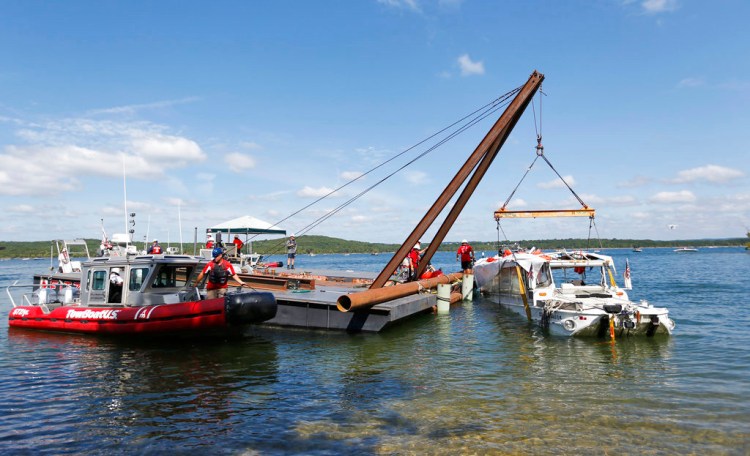 A barge crane raises the duck boat that sank in Table Rock Lake in Branson, Mo. The boat went down last Thursday evening after a thunderstorm generated near-hurricane-force winds. 