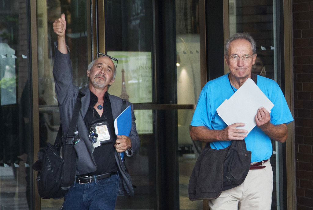 New York Daily News staff photographers Todd Maisel, left, and Andrew Savulich walk out of the newspaper's office after being laid off, Monday.