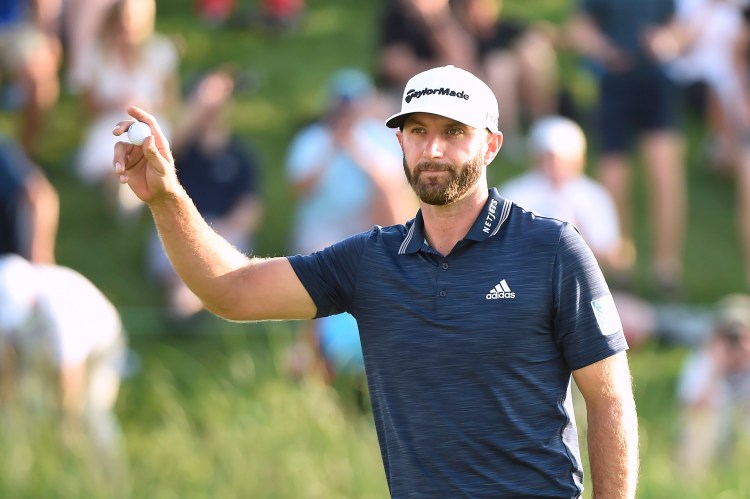 Dustin Johnson salutes the crowd on the 18th green after winning the Canadian Open on Sunday at the Glen Abbey Golf Club in Oakville, Ontario.