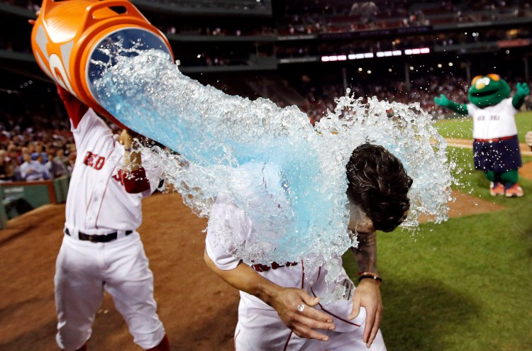 Boston Red Sox's Blake Swihart, right, is doused with sports drink after his walk-off RBI double off Philadelphia Phillies relief pitcher Luis Garcia during the 13th inning on Monday at Fenway Park in Boston. The Red Sox defeated the Phillies 2-1. At left is Boston Red Sox second baseman Brock Holt.