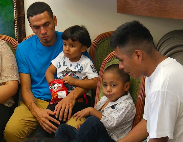 In this image taken from video, Javier Garrido Martinez, left and Alan Garcia, right, sit with their 4-year-sons at a news conference in New York on Wednesday The men were reunited with their children after almost two months of separation, Authorities took their boys them when they stopped at the U.S. southern border. 