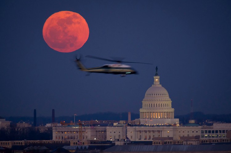 A United States Marine Corps helicopter is seen flying through this scene of the full Moon and the U.S. Capitol in 2012.