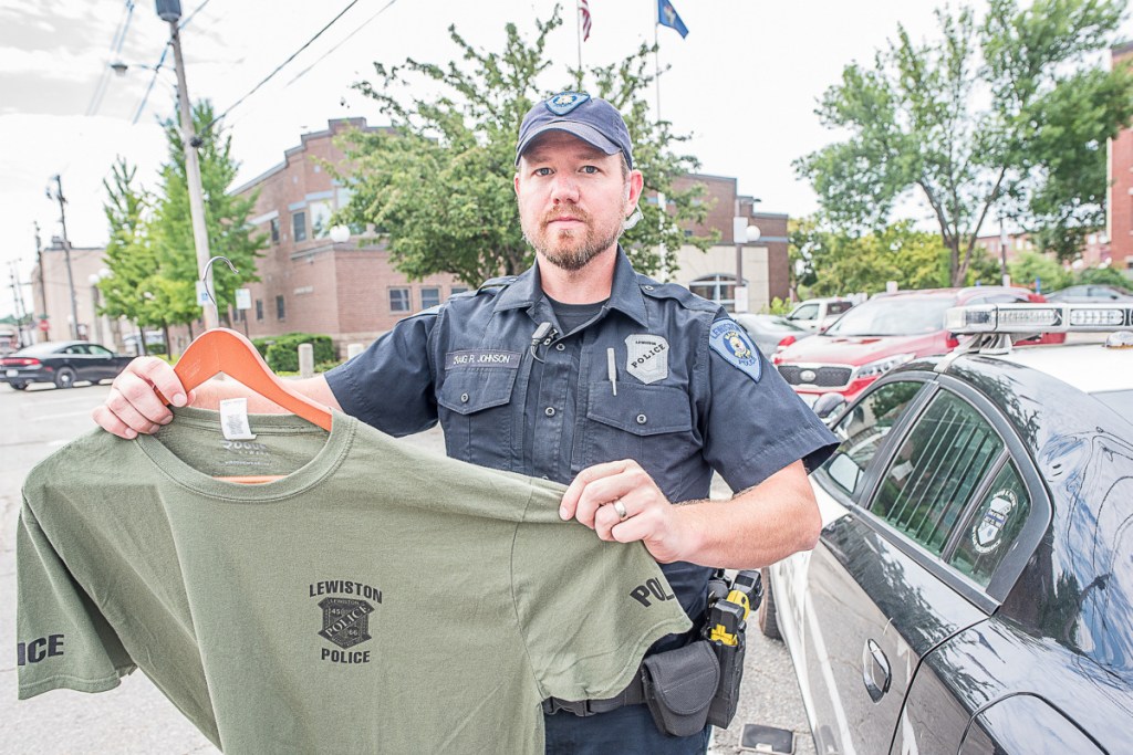 Lewiston patrol officer Craig Johnson displays a T-shirt that officers plan to wear while their union is in contract talks with the city. The current contract expired June 30.