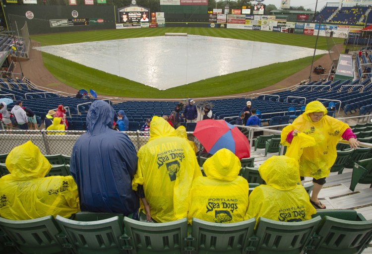 Portland Sea Dogs fans wait in their seats at Hadlock Field before Wednesday's game against the Erie SeaWolves was postponed because of rain. The teams will play a doubleheader Thursday.