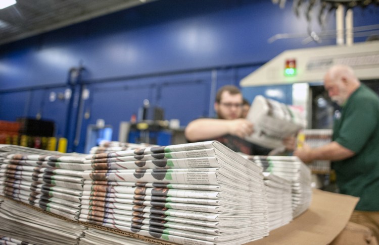 Workers stack newspapers at the Janesville Gazette printing plant in Janesville, Wis. Newsprint is usually a paper's second-biggest expense after employee wages.