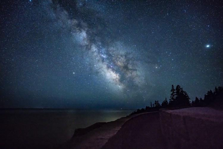 The Milky Way shines above the ocean off the coast of Acadia National Park in the early morning hours of April 23. Parks like Acadia and the Katahdin Woods and Waters National Monument are hoping to boost astrotourism by receiving a dark-sky designation from the International Dark-Sky Association.