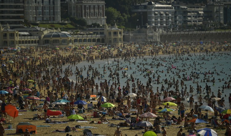 La Concha Beach in northern Spain is crowded Friday as Spaniards seek relief from a heat wave that has resulted in health warnings issued in 41 of the nation's provinces. Sahara Desert dust is adding to the misery.