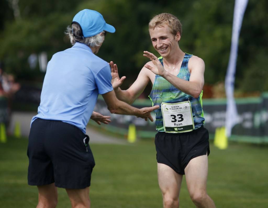 Ryan Smith of Farmington is met by race founder Joan Benoit Samuelson as finishes first among Maine runners at the 2018 TD Beach to Beacon 10K on Saturday in Cape Elizabeth. (Photo by Derek Davis/Staff Photographer)
