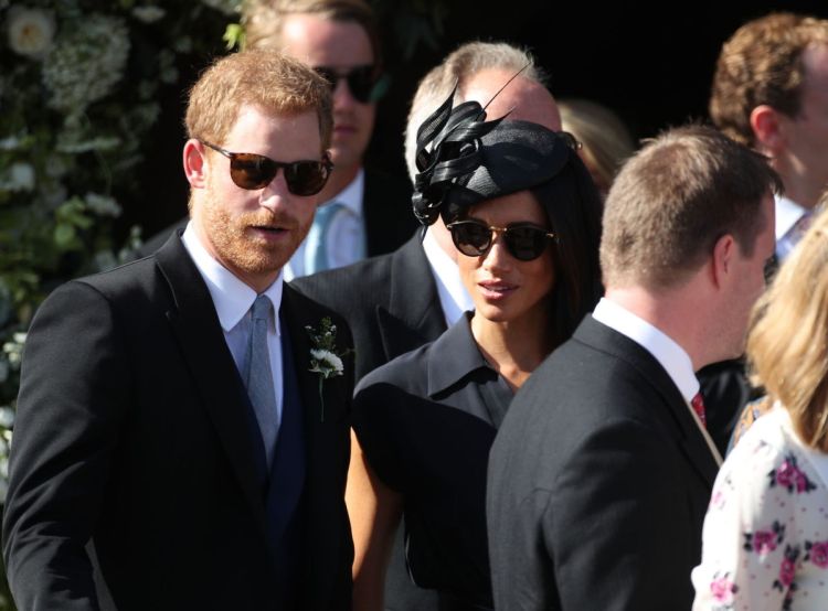 Britain's Prince Harry, left and Meghan, the Duchess of Sussex, leave St. Mary the Virgin Church in Frensham, England, after attending the wedding of Charlie van Straubenzee and Daisy Jenks on Saturday.